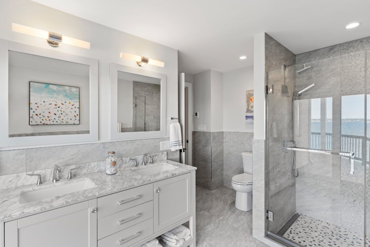Double vanity bathroom with standup shower and gray/white tile